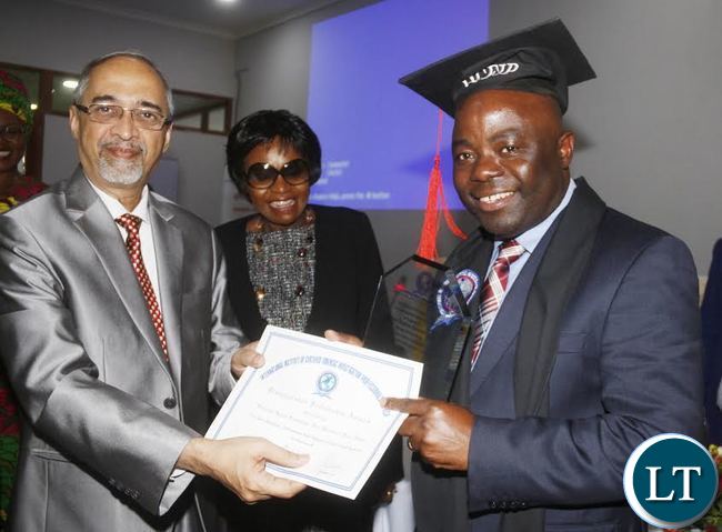 Home Affairs Minister Stephen Kampyongo receiving from International Institute of Certified Investigation Professionals USA inc (IICFIP) Global Chairperson Professor Rama Subramaniam a distinguished fellowship award while looking on is Home Affairs PS Professor Elwyn Chomba during the official launch of 2017 National Forensic Conference and Exhibition in Lusaka Mulungushi international Conference Center.
