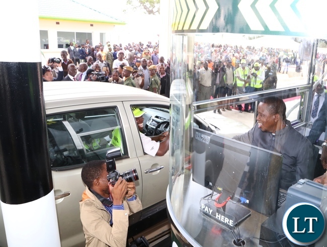 President Edgar Lungu demonstrates on how they work at the Katuba Toll Plaza booth during the Commissions of the Plaza in Katuba