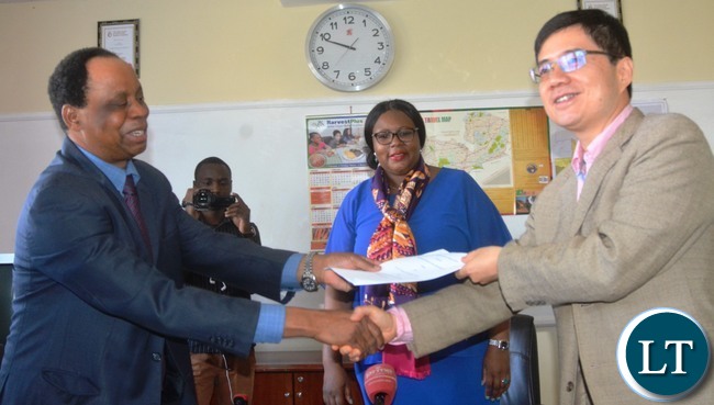 Ministry of Agriculture Permanent Secretary Julius Shawa exchange document with Avic Limited Representative Cui Ji just after the signing of a Memorandum of Understanding to construct a New National Resource Development(NRD) College in chief Shakumbila's village in Mambwa district while the Minister of Agriculture Dora Siliya looks Ministry of Agriculture Permanent Secretary Julius Shawa exchange document with Avic Limited Representative Cui Ji just after the signing of a Memorandum of Understanding to construct a New National Resource Development(NRD) College in chief Shakumbila's village in Mambwa district while the Minister of Agriculture Dora Siliya looks