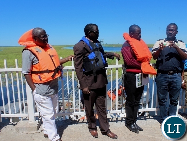 Zambezi River Authority Hydrologist Eng. Pherry Mwinga (r) explains to Zimbabwean Energy Permanent Secretary Patson Mbiri (l) and Western Province Permanent Secretary Mwangala Liomba (2nd l) during the tour of Matongo Platform, a Hydrometric Station on the Barotse Flood Plain in Mongu