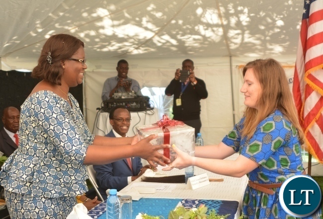 Peace Corp Volunteer Alison Flenniken(r) presents a gift of appreciation to the Minister in the Office of the Vice President Sylvia Chalikosa(l) at the Peace Corps Swearing in Ceremony for Environment and Aqua-Culture Volunteers in Lusaka