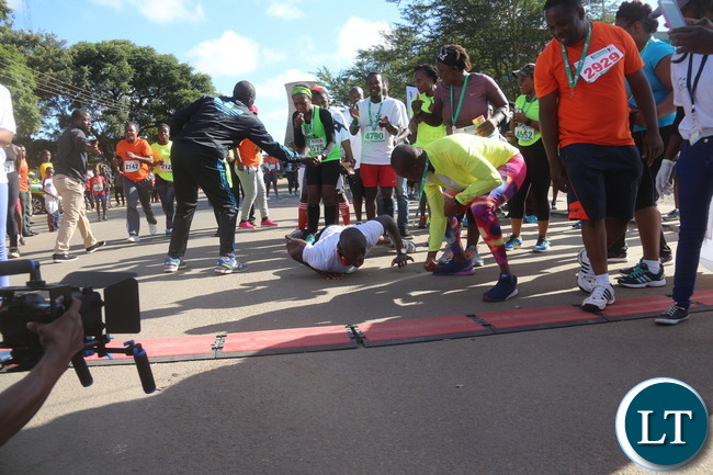 Lusaka 2017 Lafarge Marathon participant Presley Chiyesu crawling to the finishing line and he was rushed to the hospital during the even on Saturday at Lusaka Levy junction. Picture by Jean Mandela