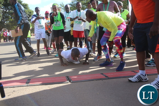 Lusaka 2017 Lafarge Marathon participant Presley Chiyesu crawling to the finishing line and he was rushed to the hospital during the even on Saturday at Lusaka Levy junction. Picture by Jean Mandela