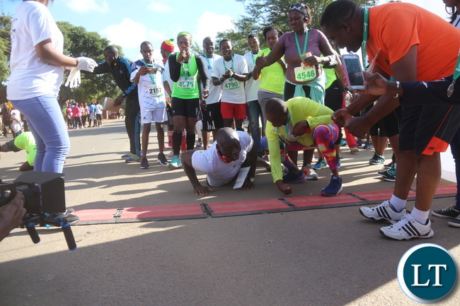 Lusaka 2017 Lafarge Marathon participant Presley Chiyesu crawling to the finishing line and he was rushed to the hospital during the even on Saturday at Lusaka Levy junction. Picture by Jean Mandela
