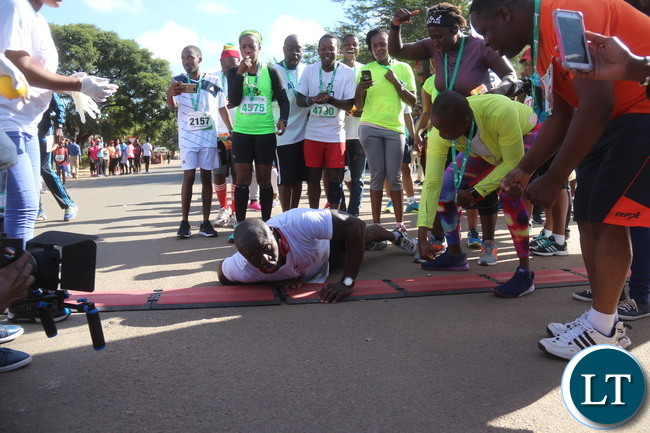Lusaka 2017 Lafarge Marathon participant Presley Chiyesu crawling to the finishing line and he was rushed to the hospital during the even on Saturday at Lusaka Levy junction. Picture by Jean Mandela
