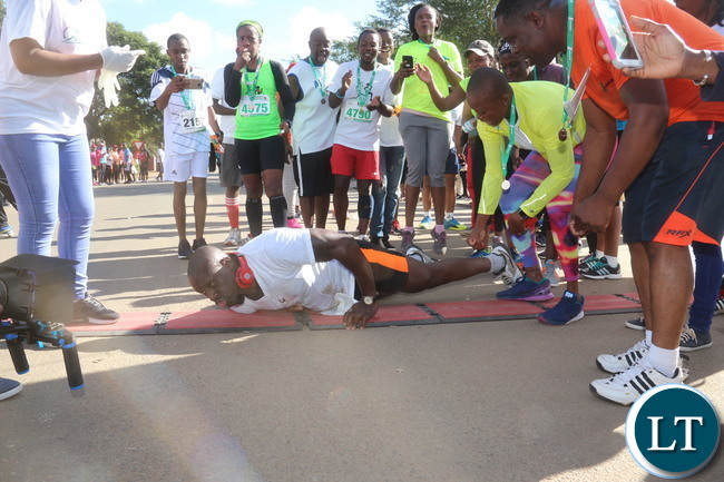 Lusaka 2017 Lafarge Marathon participant Presley Chiyesu crawling to the finishing line and he was rushed to the hospital during the even on Saturday at Lusaka Levy junction. Picture by Jean Mandela