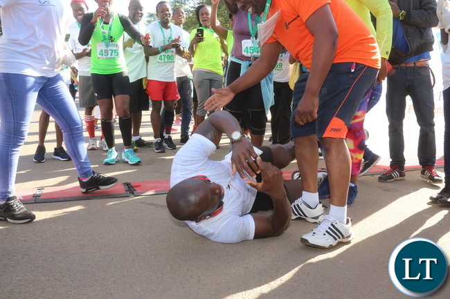Lusaka 2017 Lafarge Marathon participant Presley Chiyesu crawling to the finishing line and he was rushed to the hospital during the even on Saturday at Lusaka Levy junction. Picture by Jean Mandela