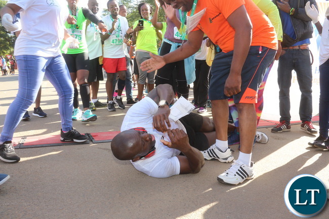 Lusaka 2017 Lafarge Marathon participant Presley Chiyesu crawling to the finishing line and he was rushed to the hospital during the even on Saturday at Lusaka Levy junction. Picture by Jean Mandela