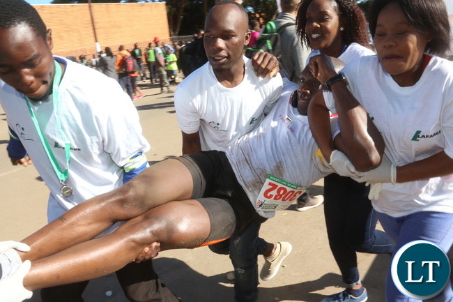 Lusaka 2017 Lafarge Marathon participant Presley Chiyesu crawling to the finishing line and he was rushed to the hospital during the even on Saturday at Lusaka Levy junction. Picture by Jean Mandela