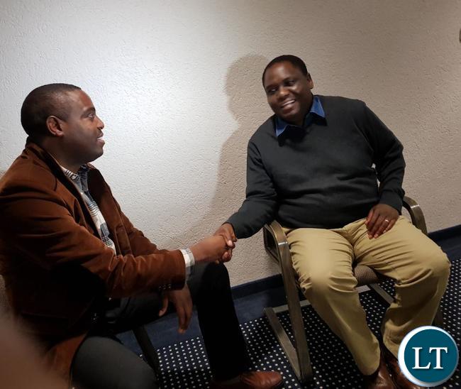 Ministry Lands PS Trevor Kaunda (r) shakes hands with Alex Simabwi