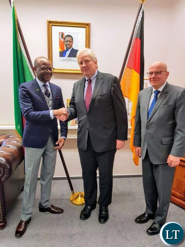 Ambassador Anthony Mukwita shakes hands with CEO of German Africa Business Association Mr. Kannengiesser in grey suit and blue neck-tie and also with Ambassador Kochanke, red neck-tie and dark suit in his office on Axel-Springer-Strasse in Berlin. Picture courtesy of the Embassy of Zambia in Germany.