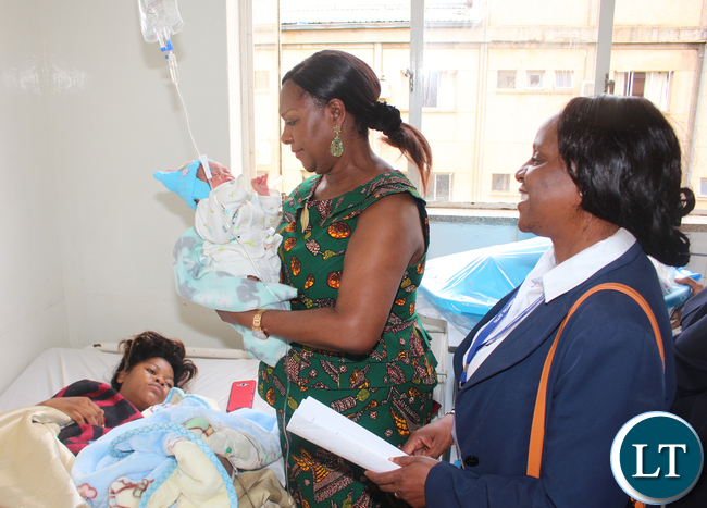 Commerce Minister Margaret Mwanakatwe admiring baby Emmanuel Mwansa baby first born of Lusaka West barracks resident 22 years old Olipah Lungu (laying down) while looking on is UTH Principle Nursing Officer Beatrice Mundia. Commerce Minister Margaret Mwanakatwe admiring baby Emmanuel Mwansa baby first born of Lusaka West barracks resident 22 years old Olipah Lungu (laying down) while looking on is UTH Principle Nursing Officer Beatrice Mundia.