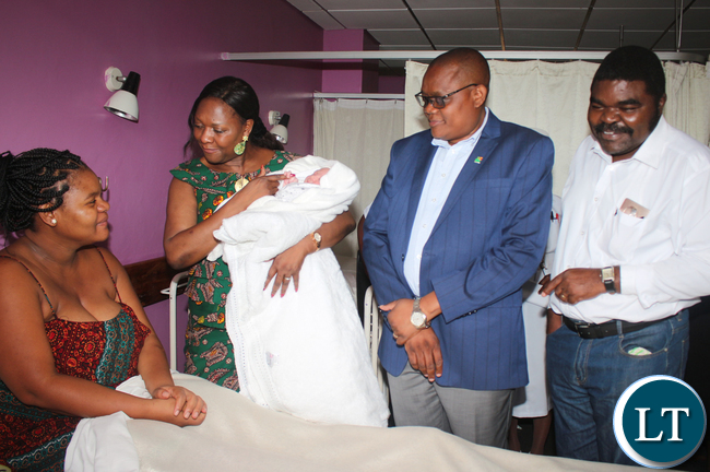 Commerce Minister Margaret Mwanakatwe holding holding Clement Chikonde Lubahya jnr baby first born of Levy Mwanawasa Hospital junior doctor Ruth Chilwa born at 0937 with 3.9 Kg while looking are Heath Minister PS Dr Malama and UTH - Head Clinic Care Dr Mulindi Mwanahamuntu at Lusaka UTH Labour ward.