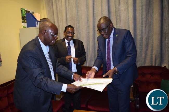Minister of Tourism and Arts Hon. Charles Banda Banda receiving Barotse Maps from renowned archeologist and author Nicholas Katanekwa.