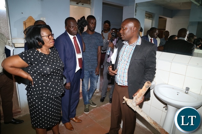 University of Zambia Resident Engineer Ally Nyirenda showing the Minister of High Education Nkandu Luo the part of the water pipes the where removed during the clean up exercise due to cholera at University of Zambia