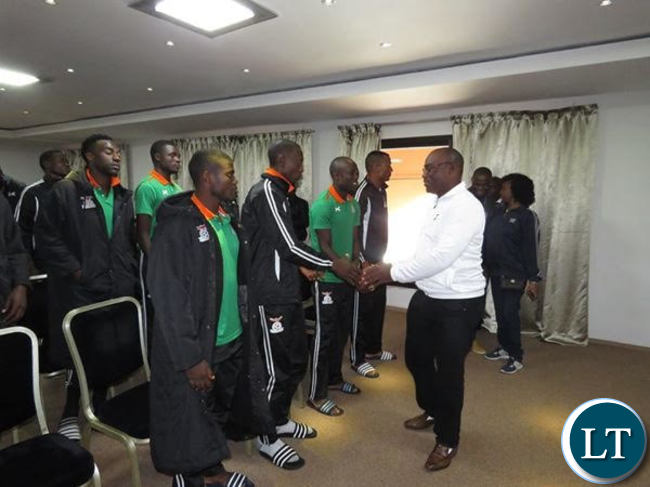 Sports minister Moses Mawere shaking hands with National team Football players