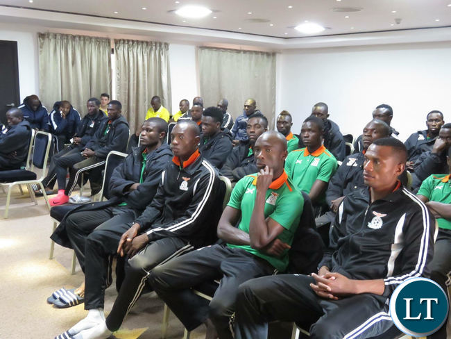 National team players listening to Sports minister Moses Mawere shaking