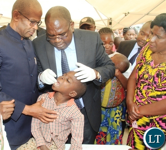 Minister of Health Dr Chitalu Chilufya giving the.oral cholera vaccine to a boy to officially launch the vaccine in Kanyama Mutanda bantu .looking on is area member of parliament Elizabeth Phiri (right) and deputy Secretary to Cabinet Patrick Mvunga (left) Minister of Health Dr Chitalu Chilufya giving the.oral cholera vaccine to a boy to officially launch the vaccine in Kanyama Mutanda bantu .looking on is area member of parliament Elizabeth Phiri (right) and deputy Secretary to Cabinet Patrick Mvunga (left)