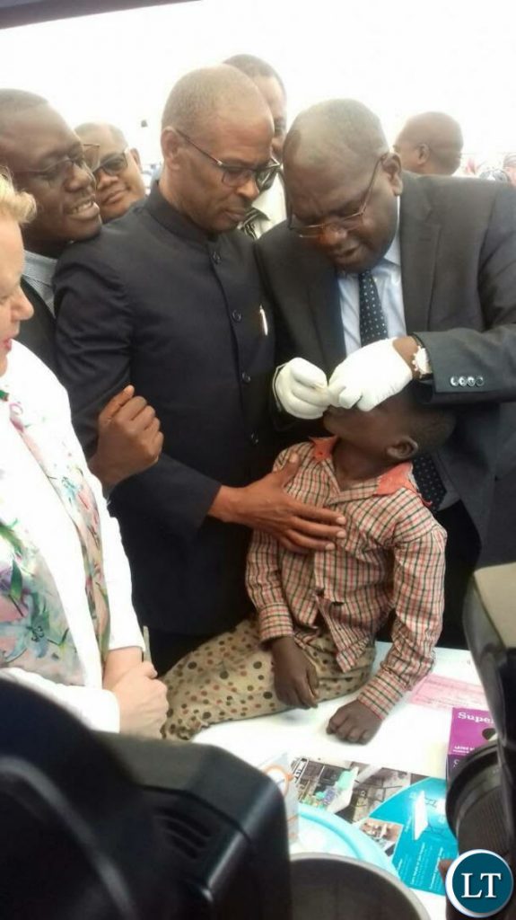 Minister of Health Dr Chitalu Chilufya giving the.oral cholera vaccine to a boy to officially launch the vaccine in Kanyama Mutanda bantu .looking on is area member of parliament Elizabeth Phiri (right) and deputy Secretary to Cabinet Patrick Mvunga (left)
