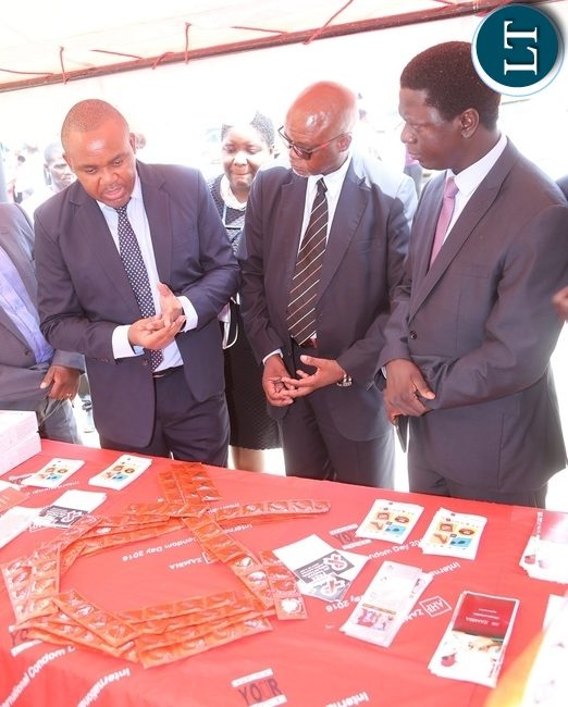 AIDS Heath Foundation Country Director Dr. Mabvuto Kango stress a point on the condoms to Ministry of Health Director Public Health Dr. Andrew Silumesii (r) and Acting Director General National AIDS Council Fortune Chibamba (2nr) during the International Condom Day tour of stands at Central Mall