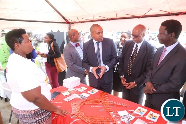 AIDS Heath Foundation Country Director Dr. Mabvuto Kango stress a point on the condoms to Ministry of Health Director Public Health Dr. Andrew Silumesii (r) and Acting Director General National AIDS Council Fortune Chibamba (2nr) whilst exhibitor Mary Chazangwe looks on during the International Condom Day tour of stands at Central Mal