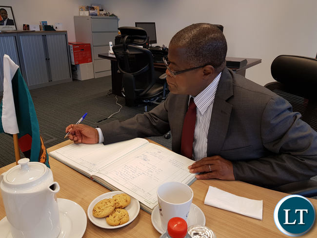 Commerce Minister, Christopher Yaluma signs the visitor’s book at the Zambian Chancery in Brussels after addressing Diplomats.