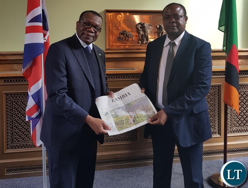High Commissioner ChiKonde presenting a supplement that appeared in the Daily Telegraph to Dr. Simwinga.