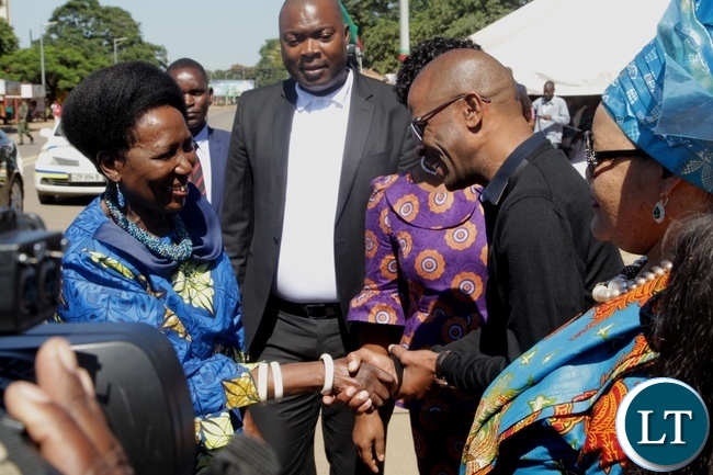 Vice President Inonge Wina is welcomed by Deputy Secretary to Cabinet Patrick Mvunga on arrival at the freedom statue for the international women's day commemoration .looking on (center) is Lusaka Province Minister Bowman Lusambo