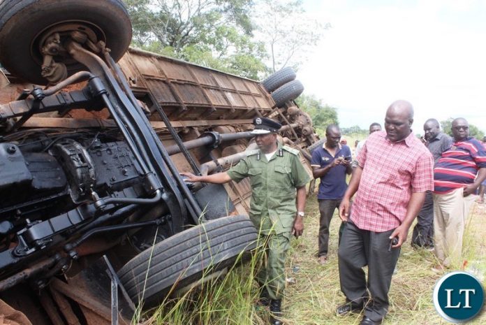 Part of the onlookers catches a glimpse of a Juldan coach Reg. No ABE 6940 which has claimed 4 lives after over turning due to allegedly failure by the driver to stop on the T-Junction along the Kasama- Luwingu road in the early hours of Monday. The driver is among the 3 men who died on the spot while one female died upon arrival at the Hospital.-Picture by Mary Bwembya (ZANIS).
