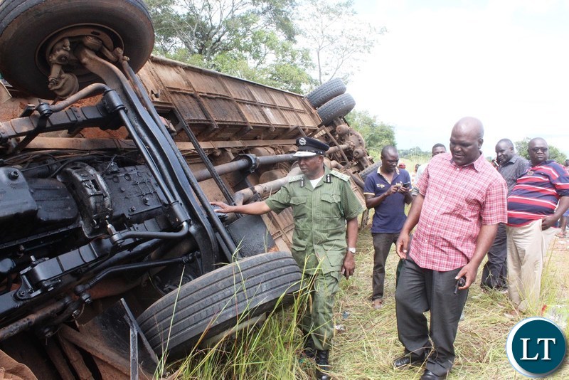 Part of the onlookers catches a glimpse of a Juldan coach Reg. No ABE 6940 which has claimed 4 lives after over turning due to allegedly failure by the driver to stop on the T-Junction along the Kasama- Luwingu road in the early hours of Monday. The driver is among the 3 men who died on the spot while one female died upon arrival at the Hospital.-Picture by Mary Bwembya (ZANIS).