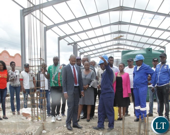 -Local Government Minister Vincent Mwale is taken on a conducted tour of the Simon Mwansa market under construction by site engineer Captain Mabvuto Lungu to check on the progress in Lusaka