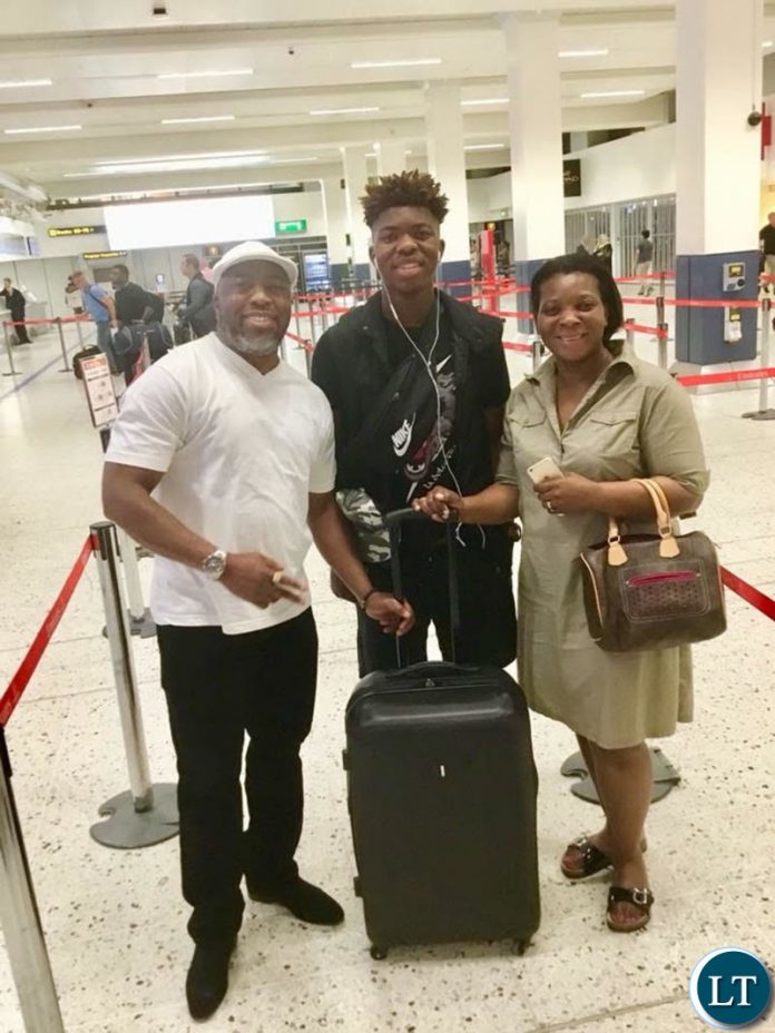 Mwiya (centre) with his parents at the airport enroute to Zambia
