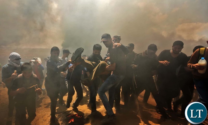 Palestinians carry a demonstrator injured during the clashes. Photograph-Mahmud Hams-AFP-Getty Images