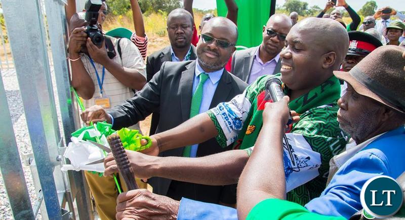 Southern Province Minister Edify Hamukale cuts the ribbon to officially commission the communication tower in Dundumwezi as Zamtel CEO Sydney Mupeta and Senior Chief Siachitema looks on