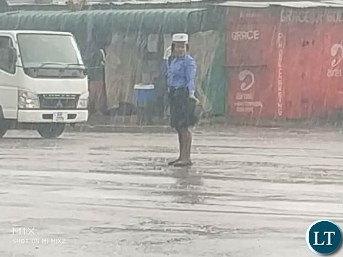 The traffic Police Officer Traffic Police Officer Charity Nanyangwe controlling traffic in heavy rains without safety attire and rain coat