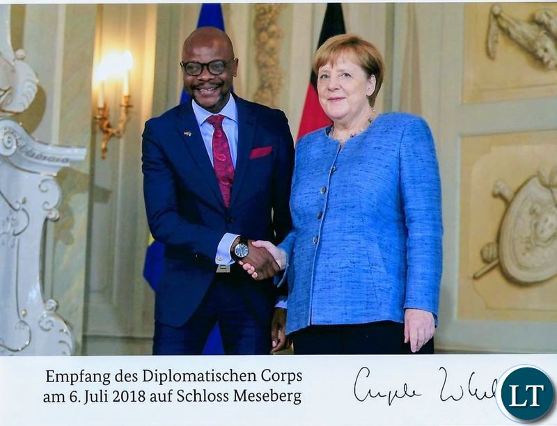 Images, chancellor Merkel shakes hands with Zambia Ambassador Mukwita,