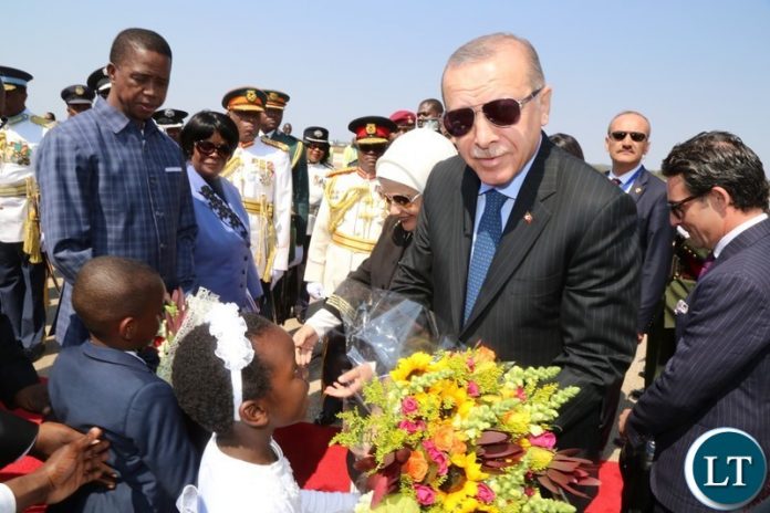 Recep Tayyip Erdogan President of the Republic of Turkey receives a bouquet of f lowers from 7 year old girl Temwani Mponela at Kenneth Kaunda International Airport.