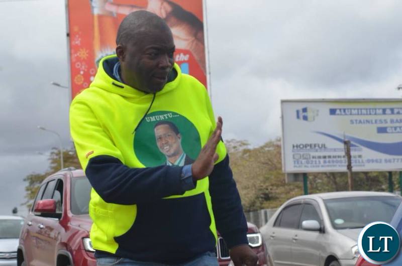 Lusaka Province Minister Bowman Lusambo waves to motorists along the Great East Road as he campaigns for Miles Sampa