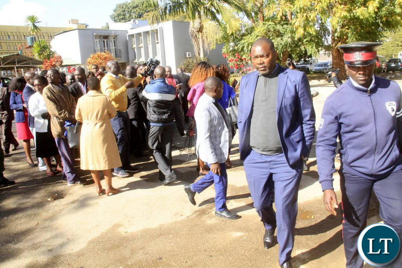 Mr Lusambo walks away from a group of civil servants who came late for work after chasing them away.