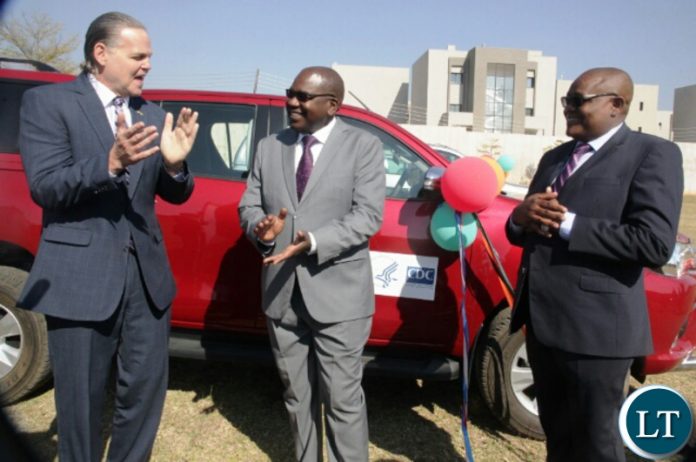 American Ambassador to Zambia Daniel Foote chatting with health Minister Chitalu and his PS for administration Kennedy Malama
