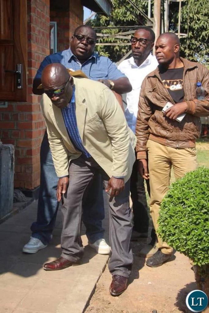 Mr Kambwili's security personnel assisting him as he prepares to file a complaint to the DEC on Tuesday