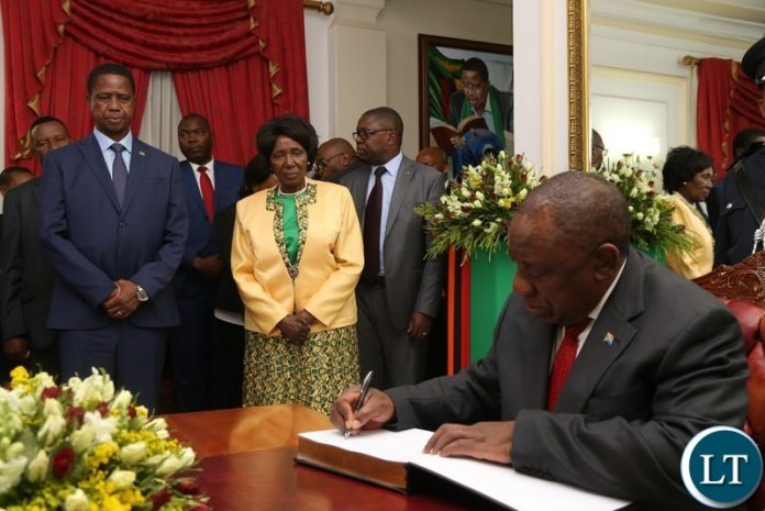 South African President His Excellency Mr.Cyril Ramaphosa signs a visitors book while President Edgar Lungu and Vice President Inonge Wina looks on at State House South African President His Excellency Mr.Cyril Ramaphosa signs a visitors book while President Edgar Lungu and Vice President Inonge Wina looks on at State House