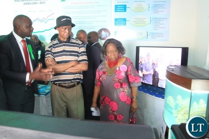President Edgar Lungu listens to Lizzen Moono Monitoring and Evaluation specialist at the Ministry of Fisheries and livestock during the tour of stands at the 92nd Agriculture and Commercial Show of Zambia