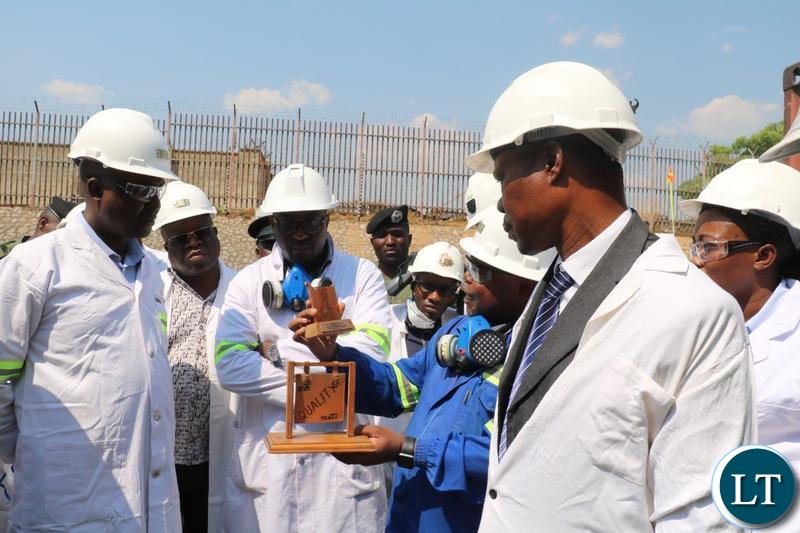 Copperbelt Minister Japhen Mwakalombe listens to Jonathan Manda Manager - Electrowinning - Nchanga Tailings Leach Plant