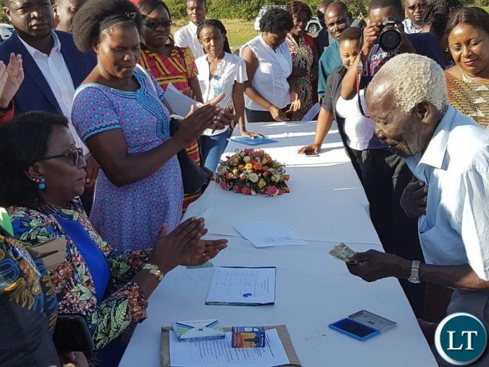Then Minister of Community Development Emerine Kabanshi pays beneficiaries of the Social Cashtransfer