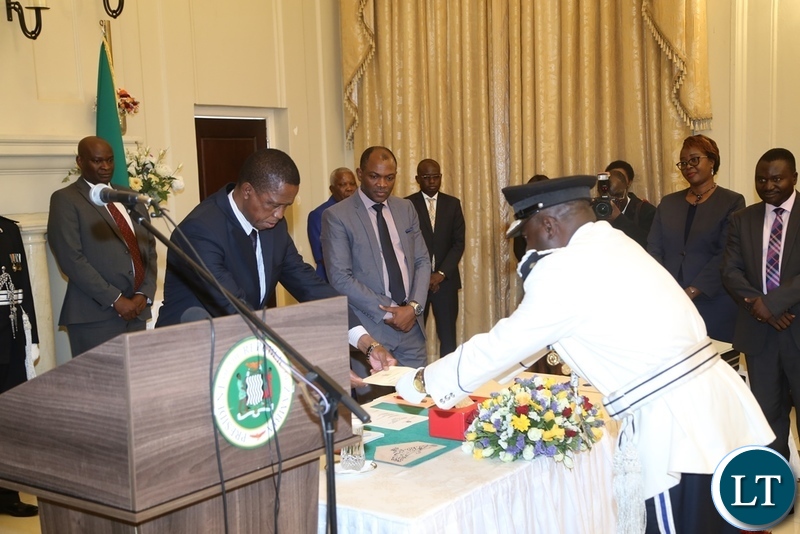 President Edgar Lungu receives the latter of Oath from the newly appointed Southern Province Police Commissioner Diamond Likashi during swearing in ceremony at State House
