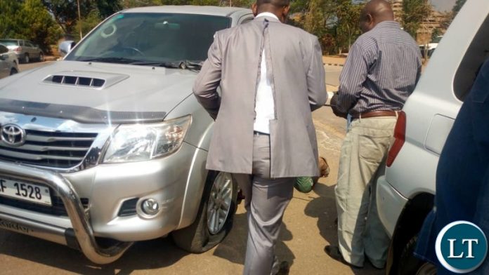 Tayali in a Torn Jacket going to his vadalised vehicle