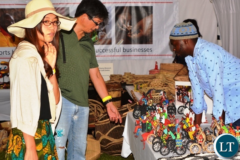 Chrisphin Siamubanga an Artisan shows the tourists art work during the Zambian Artisan Awards in Lusaka.