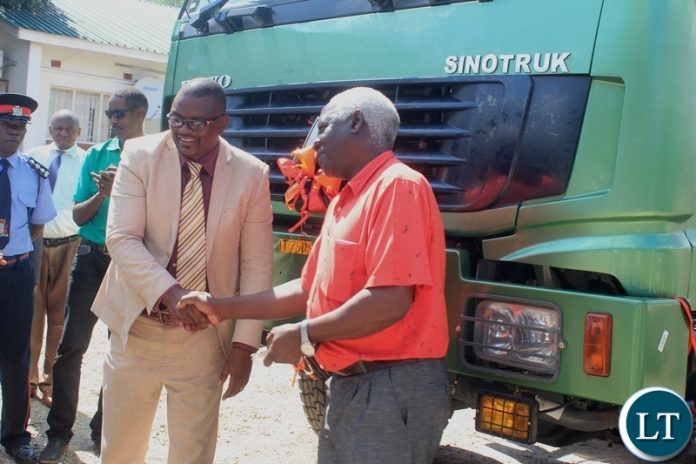 Western Province Deputy Permanent Secretary Bernard Chomba (l) congratulates Mongu Mayor Akayombokwa Kusiyo (r) shortly after handing over a truck to Mongu Municipal Council for garbage collection at a total cost of k784, 200.80 in Mongu, Western Province.