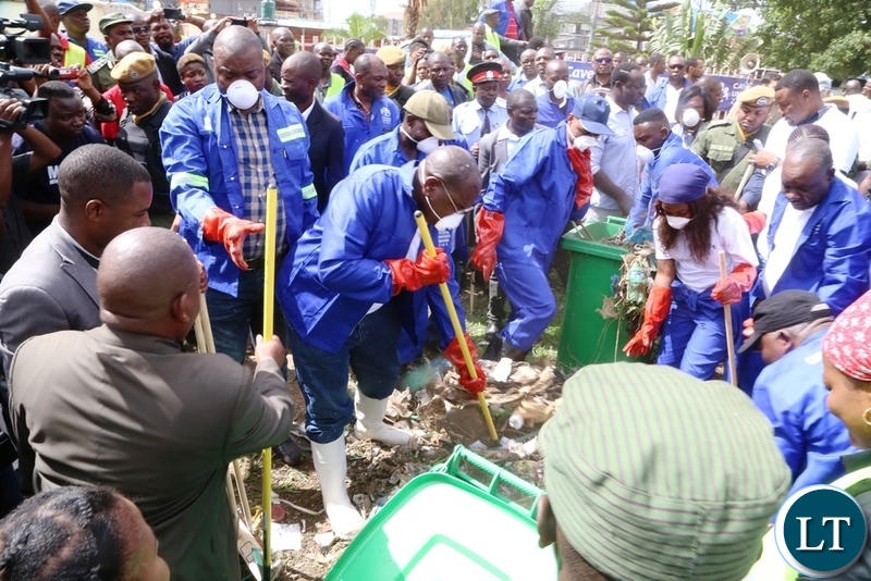 Lusaka Province Minister Bowman Lusambo and Minister of Health Chitalu Chilufya cleaning during the Cavendish University Keep Zambia Clean, Health and Green at Kafue Roundabout